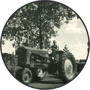 Black and white photo of Patricia Anderson driving a tractor