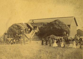 Family and helpers pose with an enormous yield of hay.