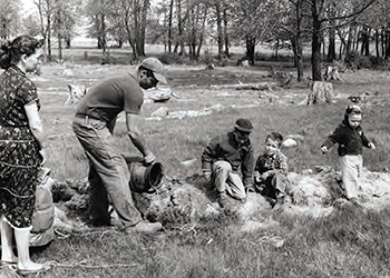 A family planting and watering trees