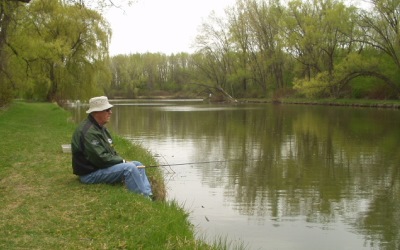 man sitting on bank who is fishing