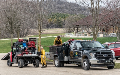 Staff re-filling a tank on a ATV with water to use on a prescribed burn.