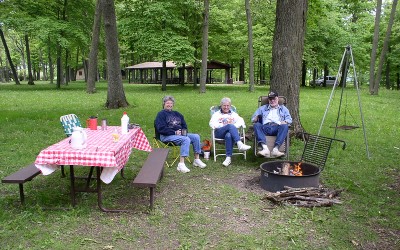 Campers around fire pit and table at Brigham County Park Campground