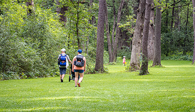 Family walking through the forested part of the Capital Springs disc golf course