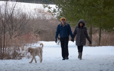 Two hikers with a dog at Prairie Moraine County Park