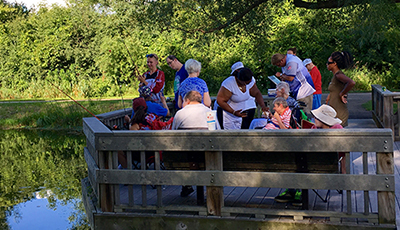 People fishing from an accessible pier at the Jenni & Kyle Preserve