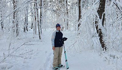 Person snowshoeing in trees covered in snow