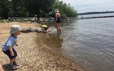 child standing on the beach looking at the water