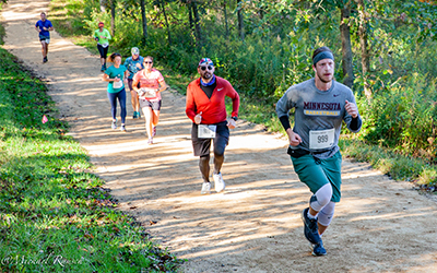 People running on a gravel trail